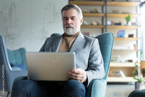 Businessman sitting in office working with laptop computer