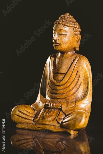 Buddha statue on table against black background