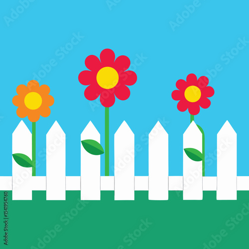 Colorful flowers growing behind a white picket fence on a bright sunny day