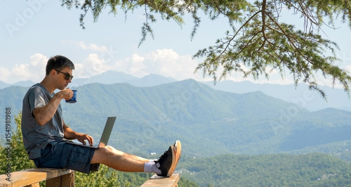 Man working remotely on laptop and drinking coffee in the mountains. Digital nomad lifestyle, freelance work in nature, summer freedom.