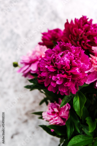 A bouquet of peonies in a vase on the table, no peole.
