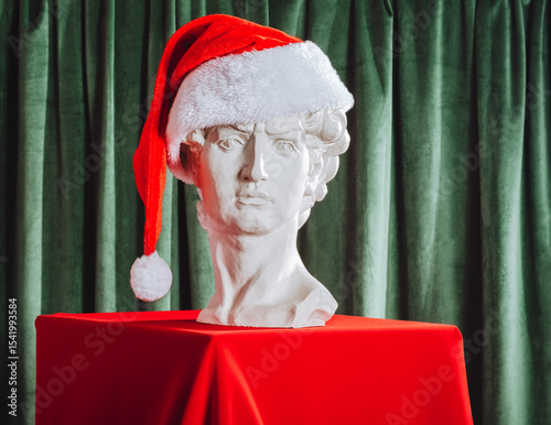 Wallpaper Mural Classical sculpture bust in Santa hat on red tablecloth with green curtain backdrop. Festive holiday concept with artistic twist. Torontodigital.ca