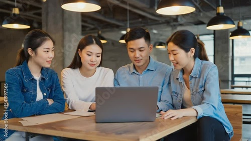 Young Adults Collaborating on Laptop in Shared Workspace