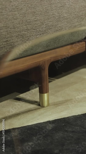 Vertical video. Close-up of a sofa with wooden legs. Stylish coffee table with a glass top combined with a beautiful wooden base for the home. No people shot