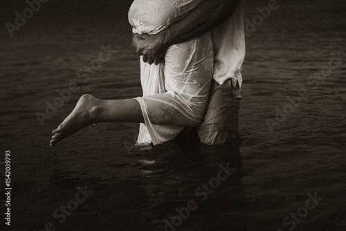 Black and white man lifting woman out of water