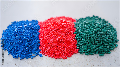 Piles of Blue, Red, and Green Plastic Granules on a Light Surface, Representing Recycling, Manufacturing, and Industrial Materials