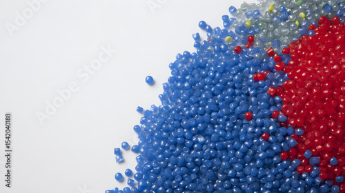 Assortment of Blue, Red, and Grey Plastic Granules on a White Background with Copy Space, Highlighting Recycling and Manufacturing Materials