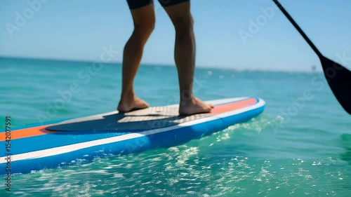 Solo man stand-up paddleboarding on calm turquoise sea under clear blue sky. Peaceful water sport moment filled with balance, freedom, and summer adventure. Ideal for travel, fitness, and ocean lifest