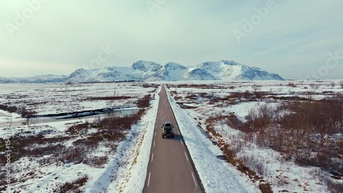 A stunning scenic winter landscape featuring a road nestled between snowcovered mountains