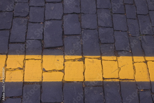 road markings on road paving stones, yellow paint on dark paving stones, 2