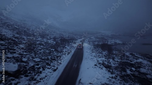 Enjoy a serene winter road journey traveling through the stunning snowy mountainous landscape
