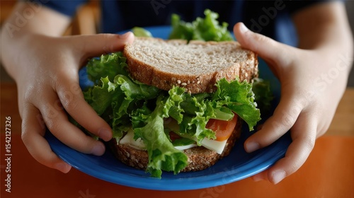 Child's hands hold a colorful school lunch with a fresh sandwich while surrounded by drawing materials and bright colors in a lunch box setting