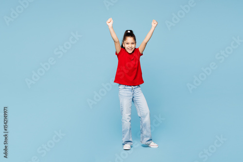 Full body little kid girl 8-9 years old wear red t-shirt have fun do winner gesture celebrate clench fist isolated on blue background child studio portrait. Mother's Day love family lifestyle concept