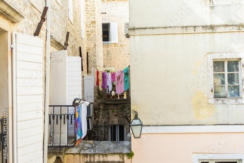 Colorful laundry hanging between old Mediterranean buildings. Everyday life, charm, and authentic atmosphere in a historic coastal town. photo