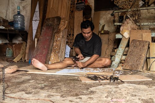 Asian carpenter creating art in Bali workshop