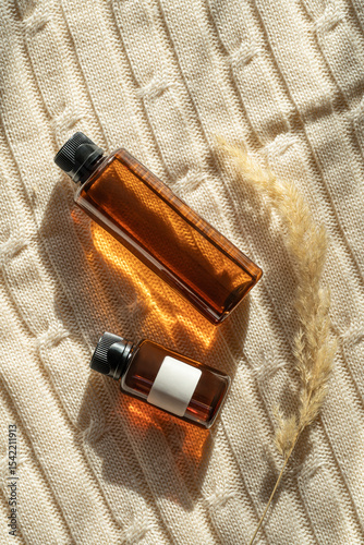 Hair care oil bottles illuminated by sunlight on fabric