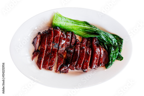 A plate of delicious Char Siu (Chinese BBQ pork) with steamed greens and dipping sauces, presented on a white background. A classic, savory Asian cuisine.