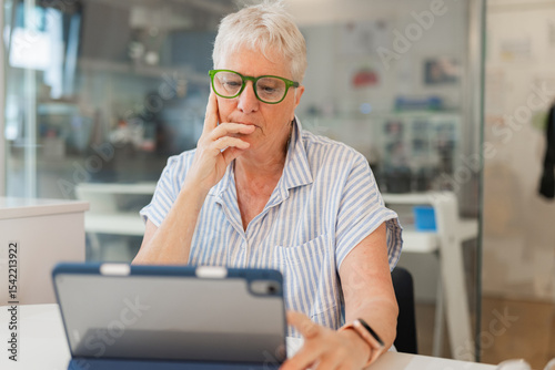 Elderly woman with tablet at home