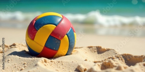 Brightly colored volleyball nestled in soft sand, photography, sun, texture