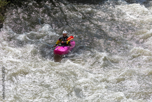 Kayaker Conquering Rapids in Vibrant Pink Kayak