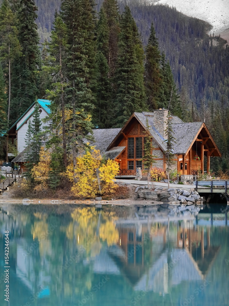 Fototapeta premium Tourist buildings at the west end of the Lodge Peninsula, off Emerald Lake south bank, backed by a dense conifer forest. Yoho NP-BC-Canada-361