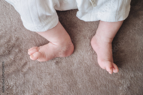Newborn baby feet resting on soft blanket