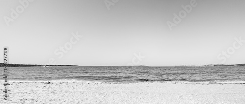 Beach, sea, empty sky and island in the distance