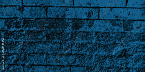 Blue-scale image of a building exterior, highlighting intricate patterns and shadows cast on its textured walls.
