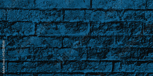 Blue-scale image of a building exterior, highlighting intricate patterns and shadows cast on its textured walls.
