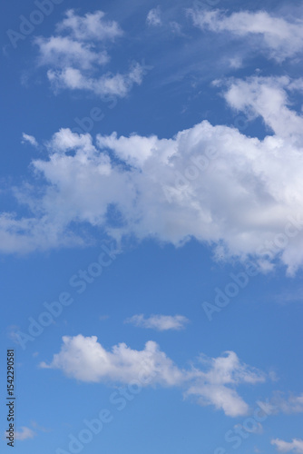 White clouds against the blue sky. Sky background. Summer. Landscape. Soft white clouds against the blue sky. Calm and serene atmosphere. White fluffy clouds
