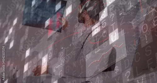 Doctor reviewing patient documents, lifting, rotating X-ray film toward light for medical diagnosis