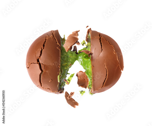 Cracked chocolate shell with green filling splashing out. Dubai chocolate is made with pistachio paste and kadayif