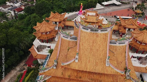 Thean hou temple rising prominently through kuala lumpur skyline, towering six levels amid verdant landscape and surrounding residential architecture