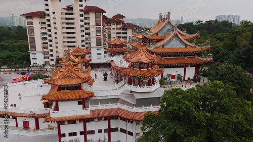 Traditional chinese temple roof architectural elements featuring ornate dragon sculptures, hanging lanterns, intricate wood carvings at kek lok si temple, penang