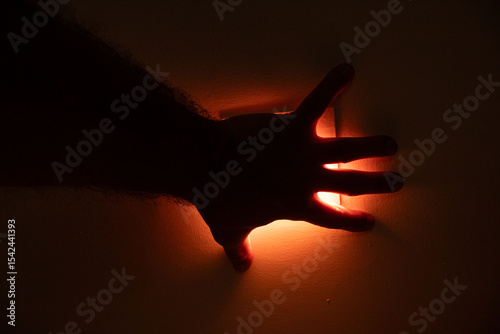 Mão aberta mostrando todos os dedos em uma contra-luz. 