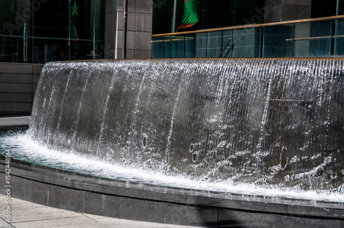 Waterfall water feature in an urban public space with water cascading over the curved rim_20101217_05175.