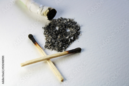 An extinguished cigarette and its ashes form a symbol of death