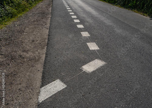 Wallpaper Mural Close-up of white road marking line on asphalt road surface, showing transportation and traffic control detail. Driving safety and road infrastructure background Torontodigital.ca