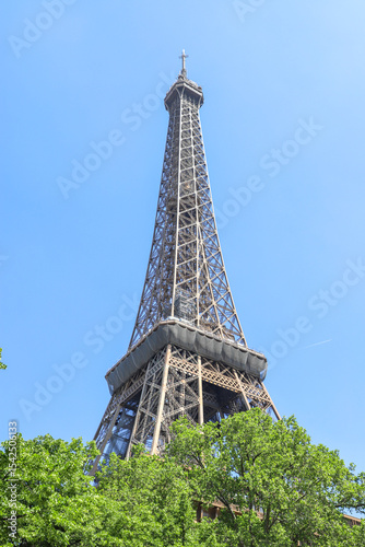View of the Eiffel Tower, Paris, France on a sunny day - Vista de la Torre Eiffel desde la base entre árboles 
