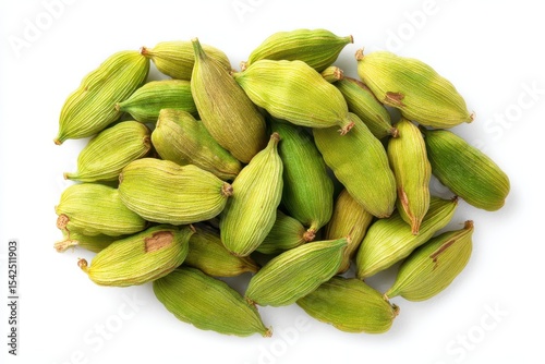 Flat lay of green cardamom seeds on a white surface
