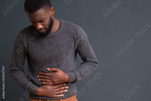 Young African man in distress clutching his stomach