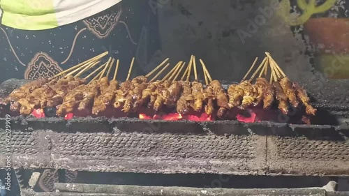 Experience authentic Indonesian sate grilling over hot coals. This mouthwatering culinary delight showcases flavorful meat skewers, prepared with local spices.