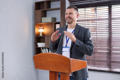 Wallpaper Mural Man giving public speech with microphone at lectern indoors Torontodigital.ca