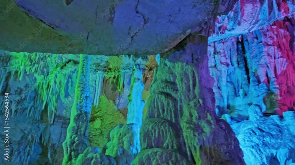 Luminous Cave Formations: Stalactites and Stalagmites in Green and Blue Light