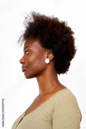 Young black woman, with natural hair, poses in profile, looking away, on white background