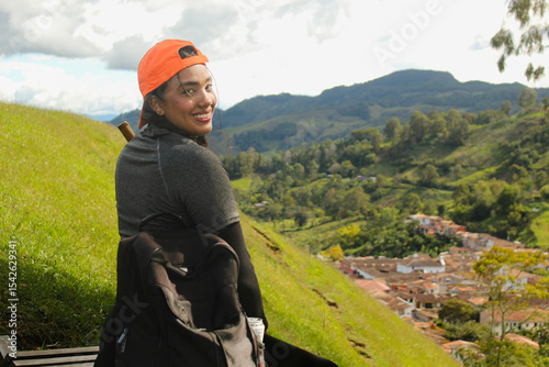 Photos beautiful woman with an orange cap, sports clothing, a backpack, and a hiking po