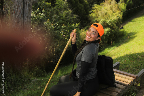 Photos beautiful woman with an orange cap, sports clothing, a backpack, and a hiking po