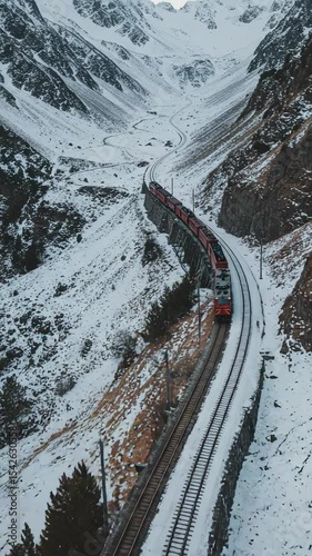 Scenic Winter Train Journey Through Snowy Mountains with Curved Tracks and Majestic Landscapes