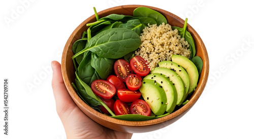 Hand holding a wooden bowl filled with spinach quinoa tomatoes and avocado slices with black seeds
