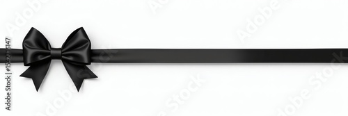 A black satin ribbon tied in a bow, lying flat on a white background